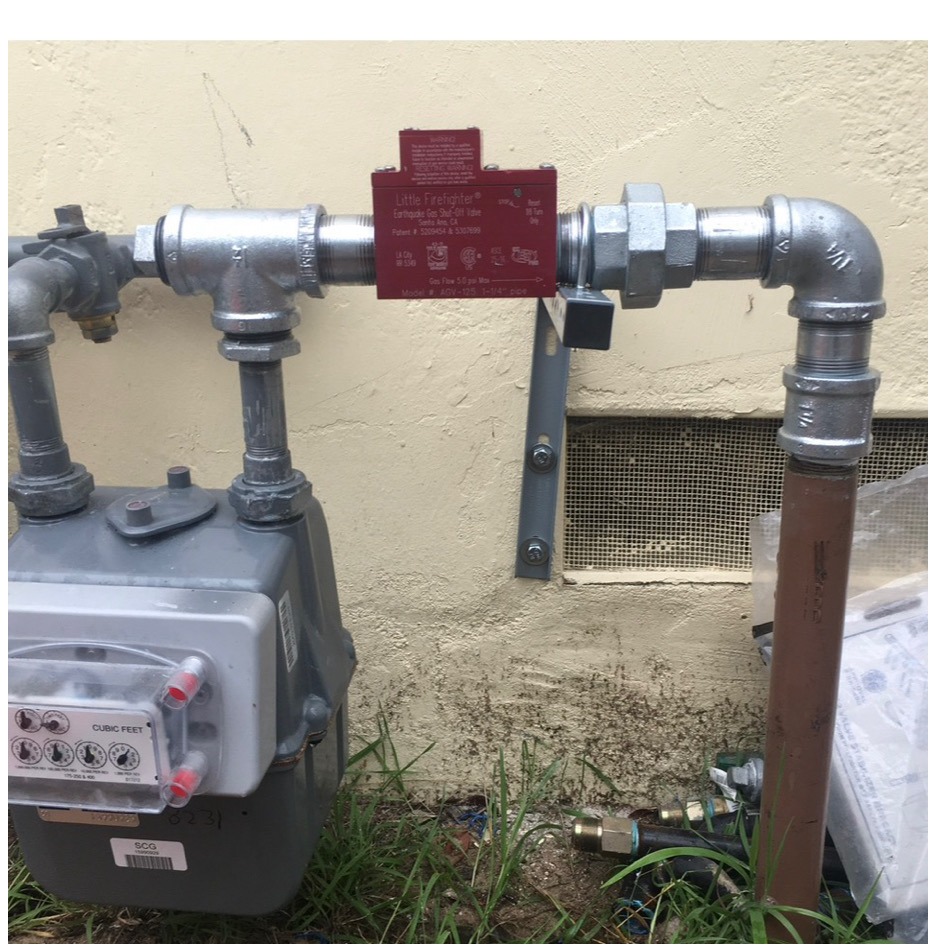 Earthquake safety valve on galvanized gas piping above an exterior gas meter