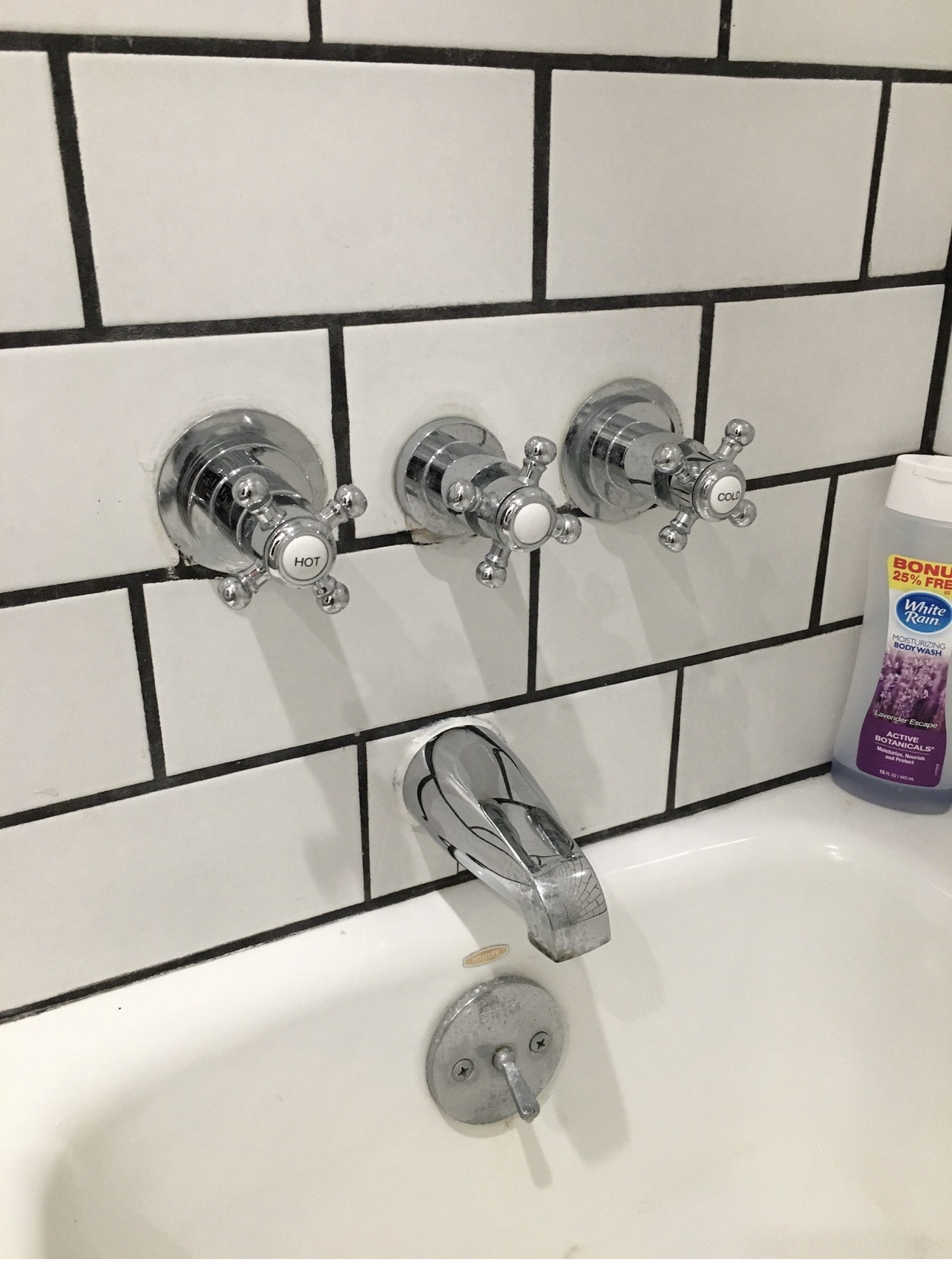 Chrome bathtub faucet and wall-mounted hot and cold water controls