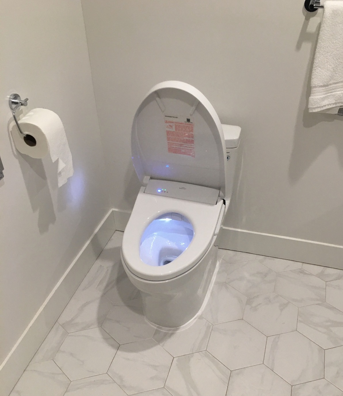 Modern white toilet fixture installed in a finished residential bathroom