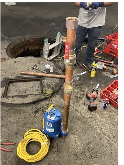Pump installation and piping work being completed at a jobsite